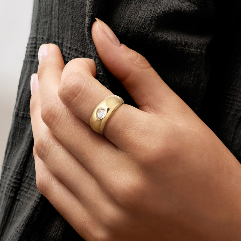 Pear-shaped diamond ring in 18kt yellow gold, worn on hand with slim band