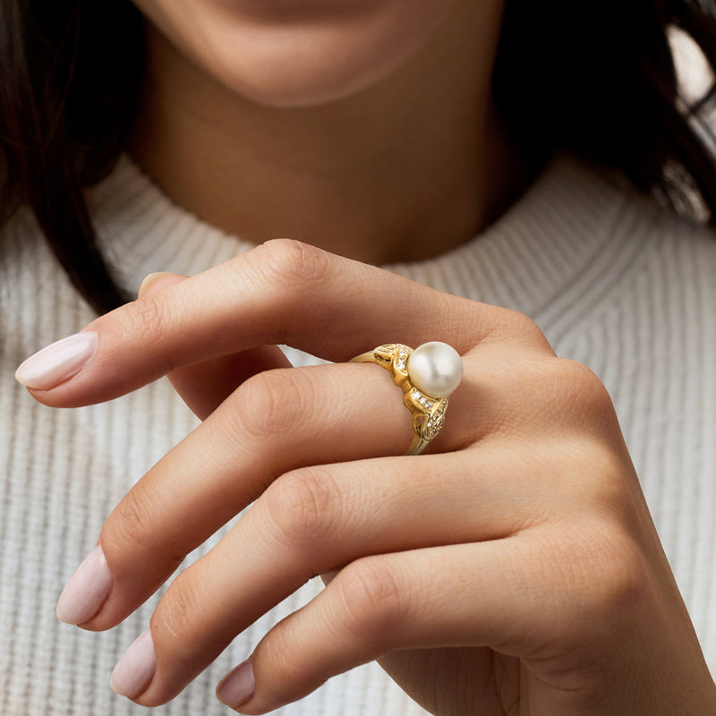 Cultured pearl and diamond ring in 14kt yellow gold, worn on hand.