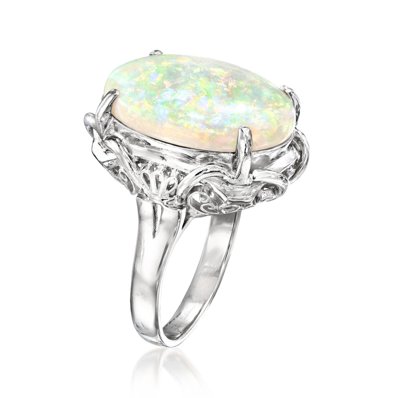 Oval opal cabochon ring with ornate openwork platinum-toned band, side view, size 7