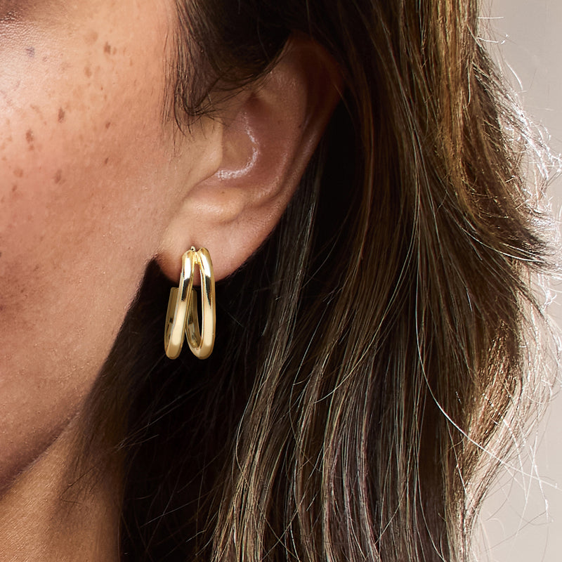 Gold-plated double-row J-hoop earrings on ear, shiny gold