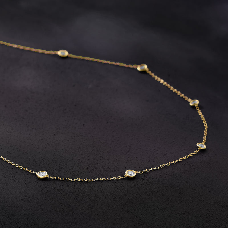 Gold station necklace close-up with round lab-grown diamond stations on cable chain
