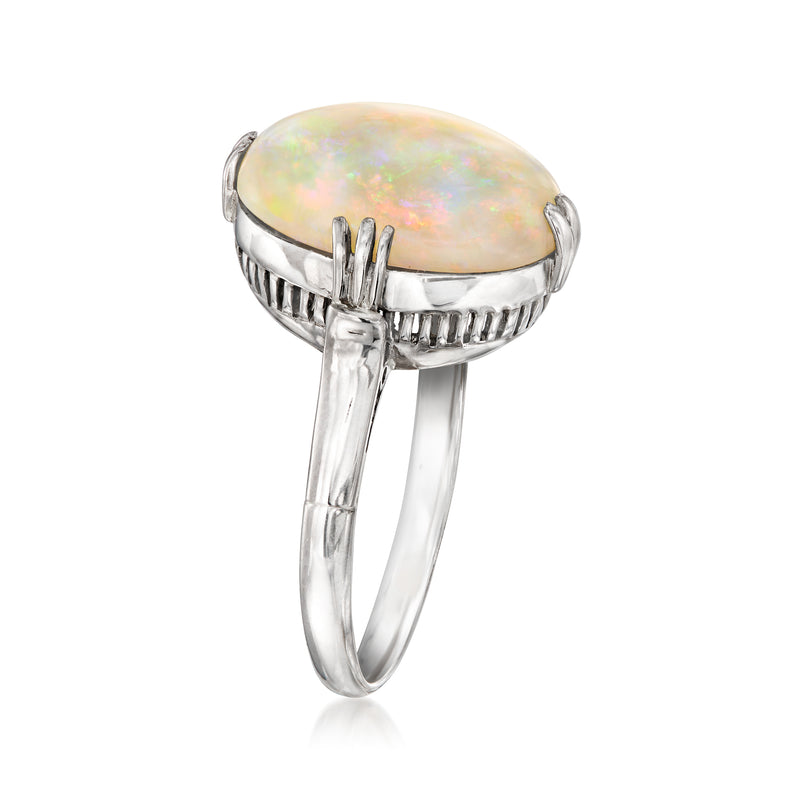 Platinum ring with oval opal top and scalloped bezel shoulders, side profile.