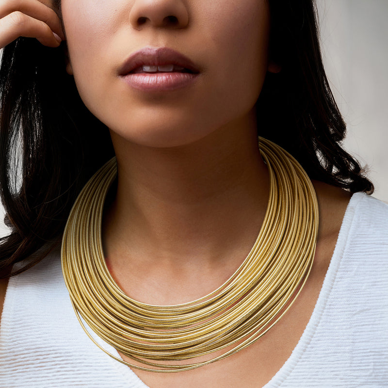 Gold over sterling multi-strand flex necklace worn with layered wire strands