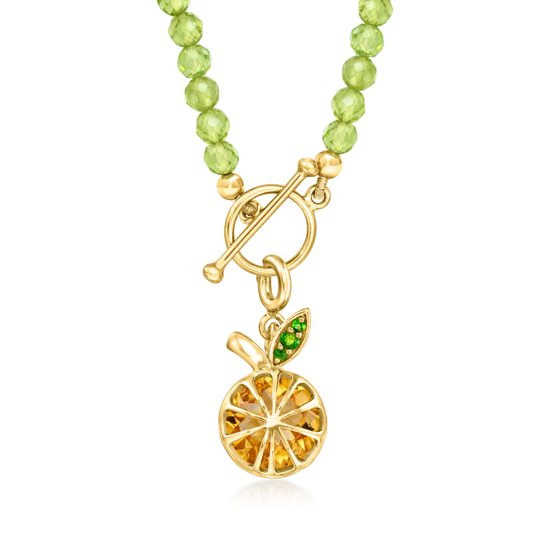 Gold-tone lobster clasp charm with orange citrine slice and green detail drop