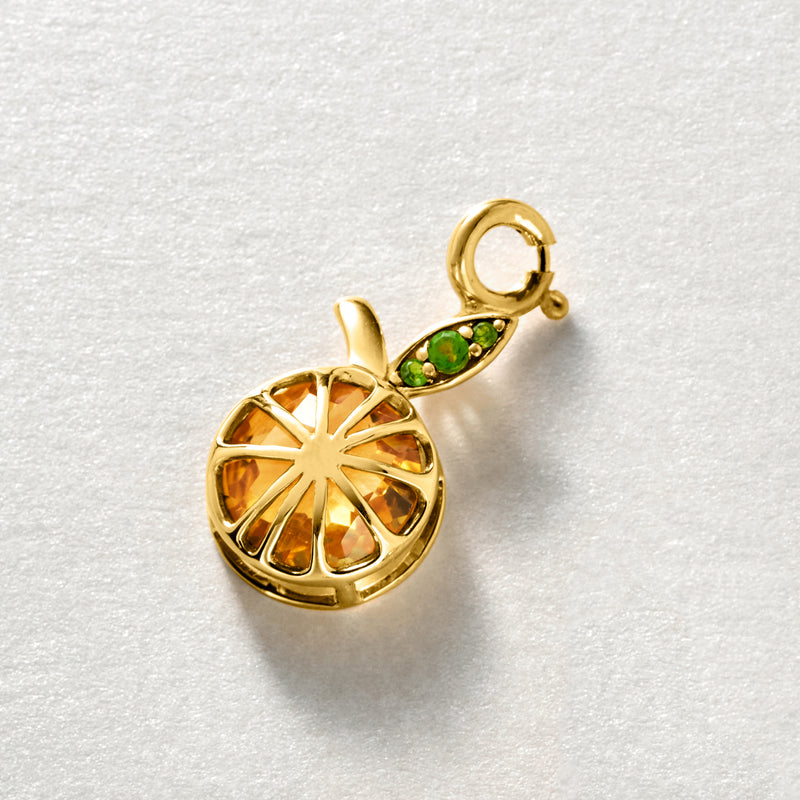 Gold-tone orange citrine slice charm with green stone leaf detail and top loop bail