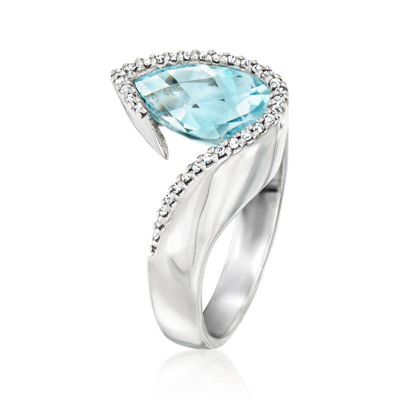 White gold ring with oval light blue topaz and diamond halo, curved side prongs