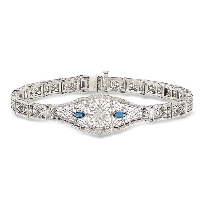 Vintage filigree bracelet with white metal tone, blue stones, and geometric link design