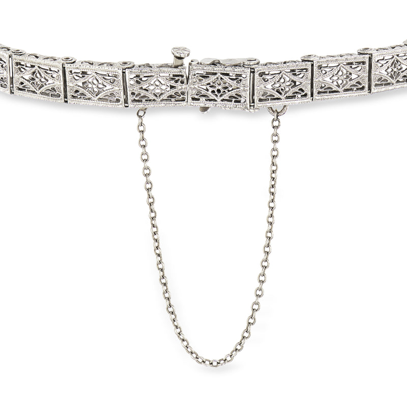 White metal filigree bracelet with repeating rectangular panels and a dangling chain section