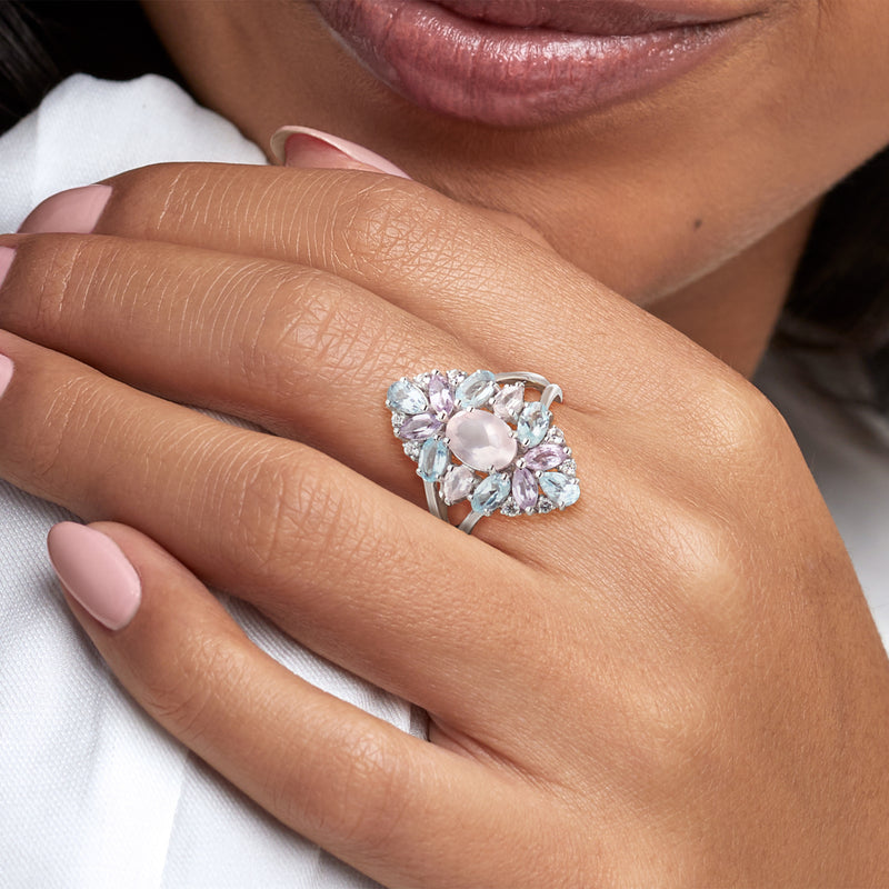 Sterling silver pastel gemstone ring on finger, oval pink center with blue accents