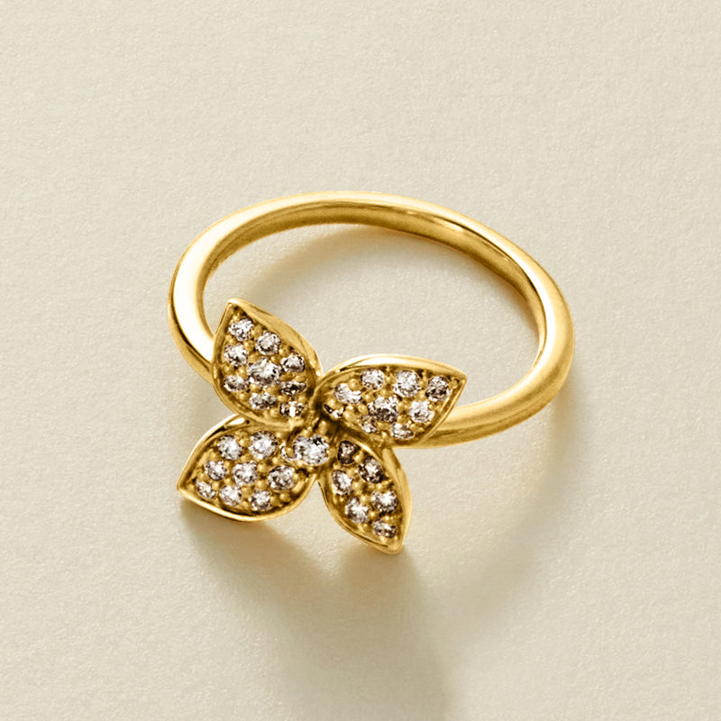 Gold diamond flower ring close-up showing band and round stones in petal settings