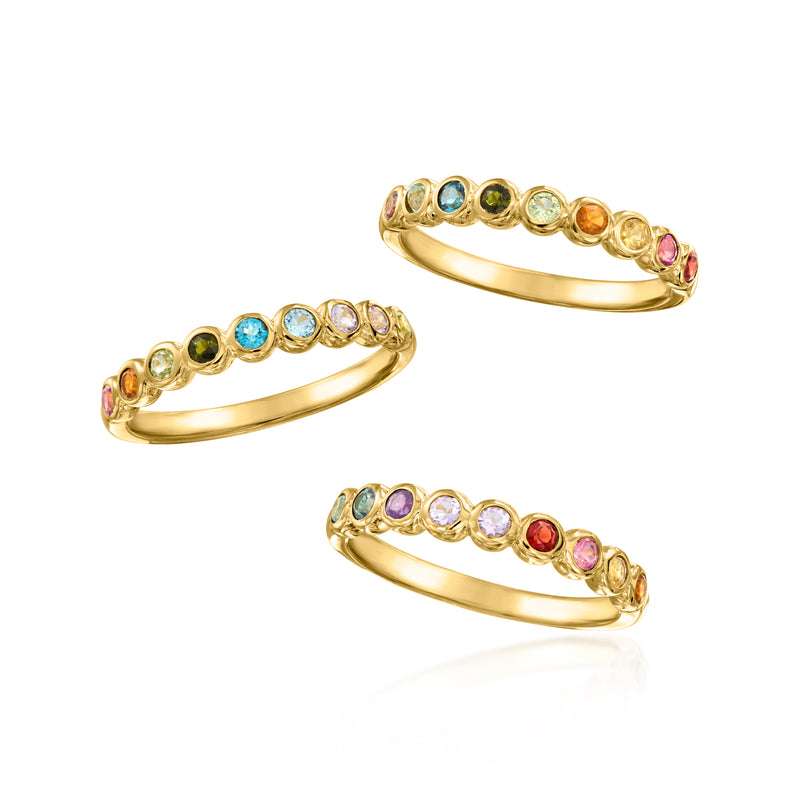 Set of three gold-tone stackable rings with round multicolor gemstones, angled view