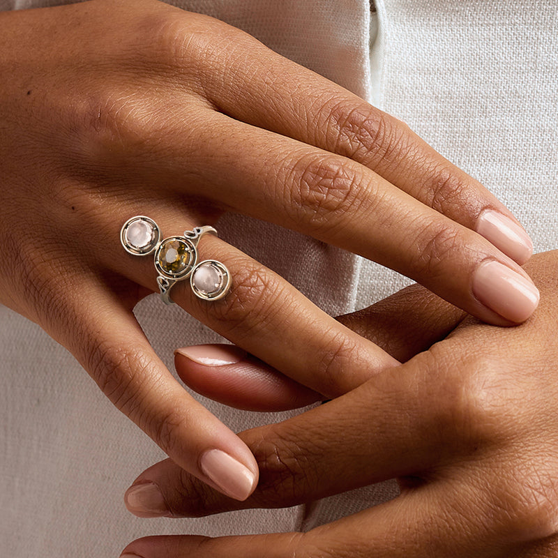 Gemstone ring in platinum and yellow gold on hand, three bezel-set stones visible