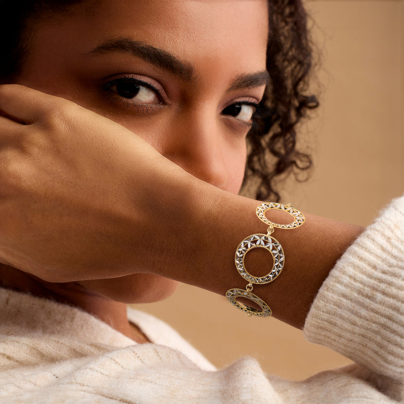 Two-tone gold circle bracelet on wrist with round medallion links