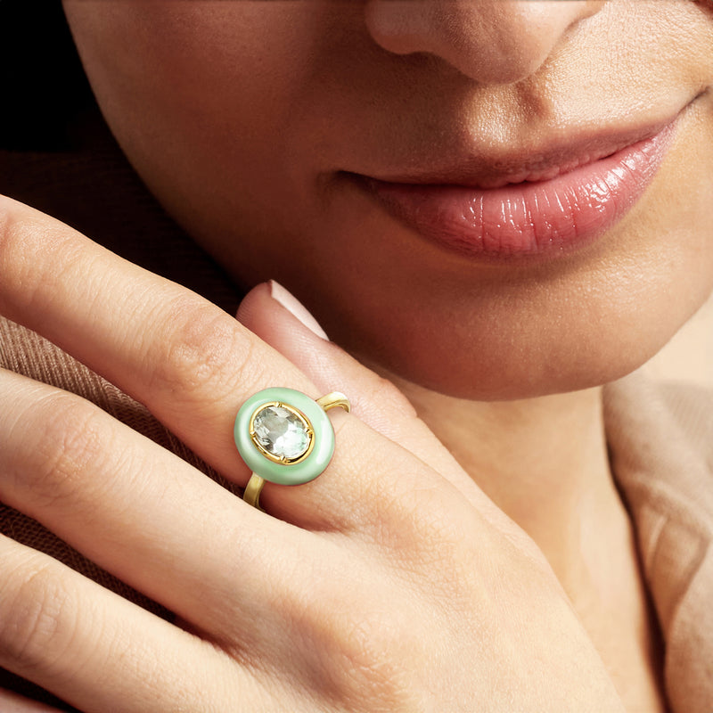 Pastel green enamel oval gemstone ring on hand with gold band