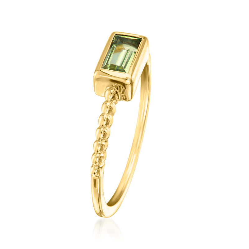 Gold-tone ring with rectangular green gemstone and dangling chain detail