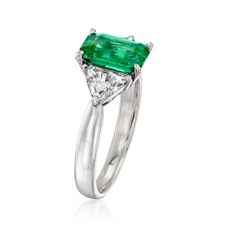 Angle view of platinum ring with emerald rectangular center and triangle diamond accents