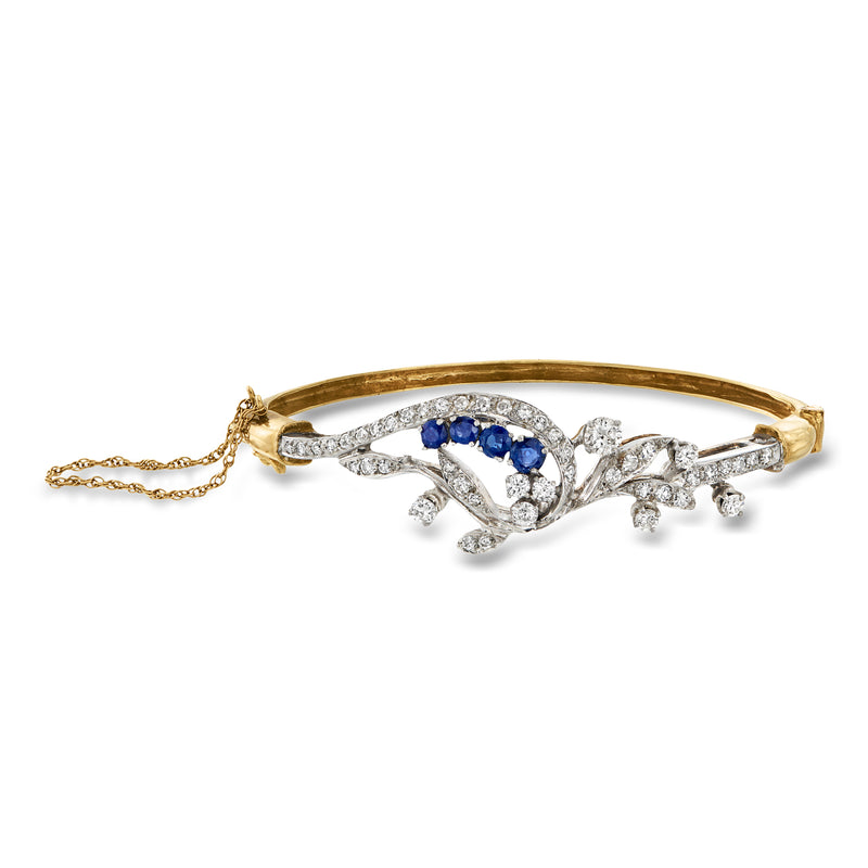 Floral bangle bracelet with blue center stones and diamond accents, yellow gold and palladium