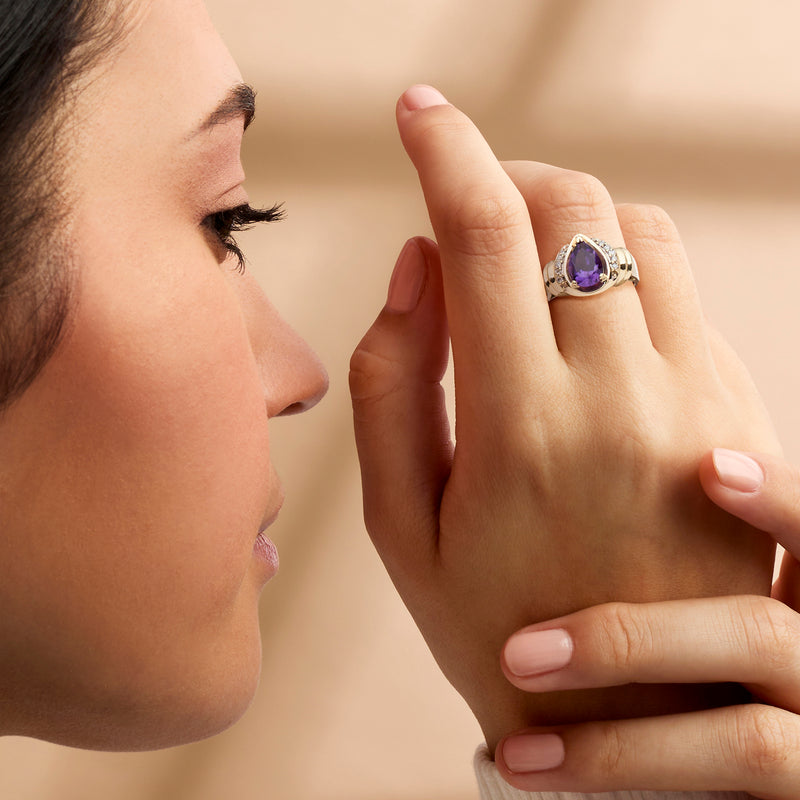 Amethyst and diamond yellow gold ring worn on hand, showing purple center stone