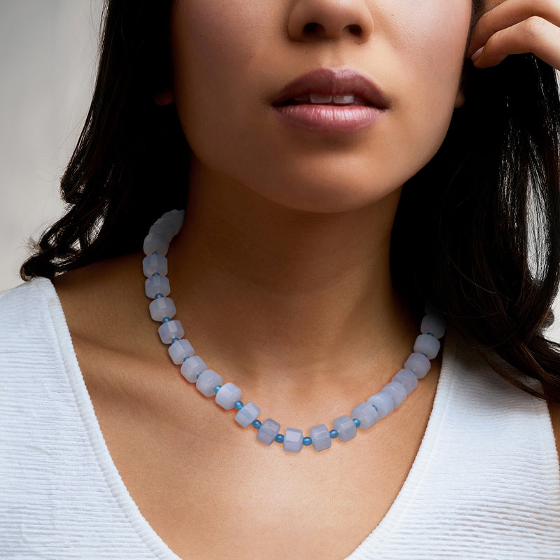 Light blue beaded necklace worn close to the neck with cube beads
