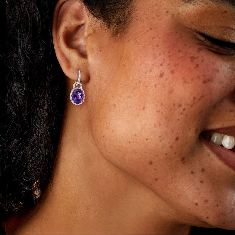 Amethyst hoop drop earrings on ear, oval purple stone with small diamond border