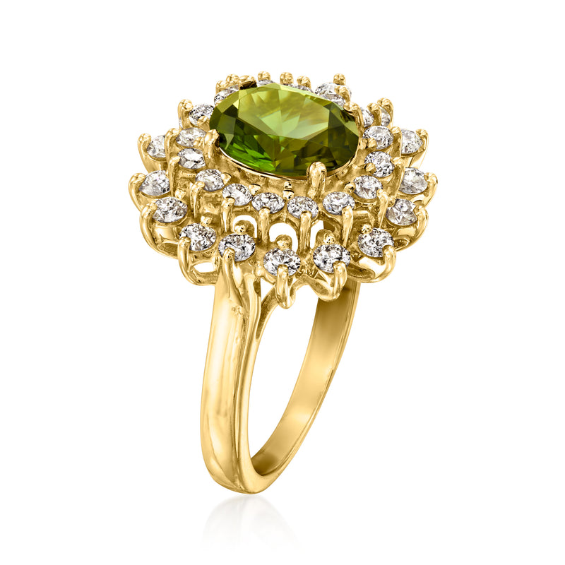 Yellow gold ring with green tourmaline center framed by diamond clusters, angled view