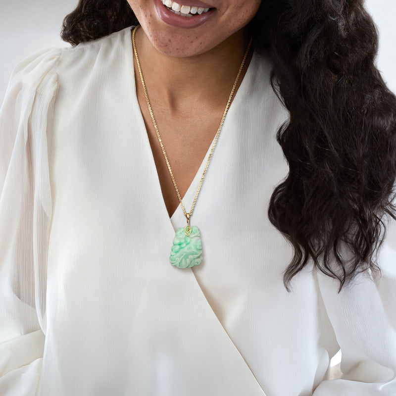 Gold chain necklace with green jade Buddha flower pendant worn at neckline