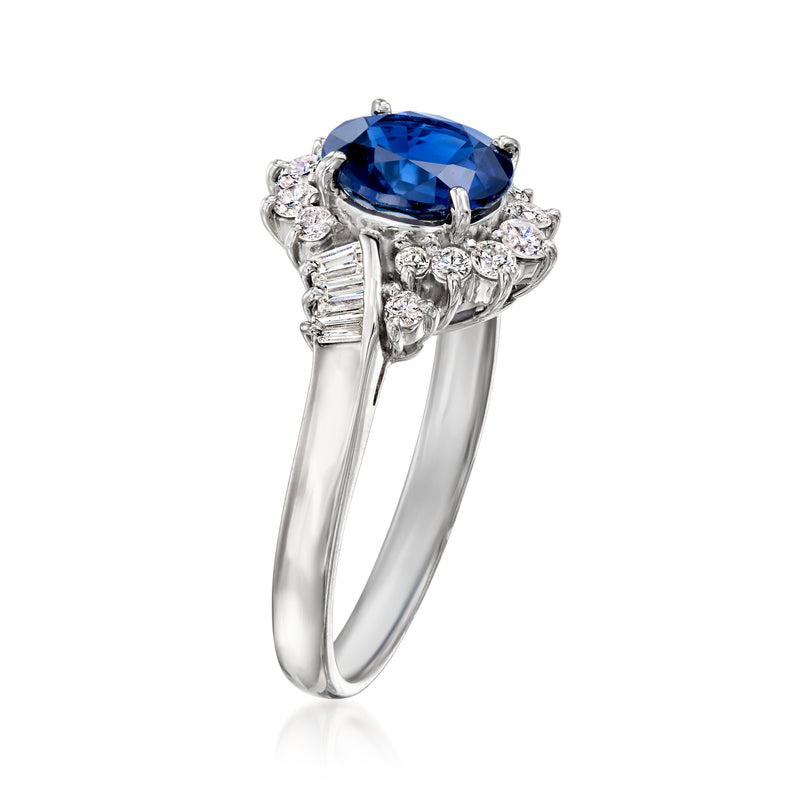 Platinum ring with blue sapphire in prong setting and curved diamond side clusters