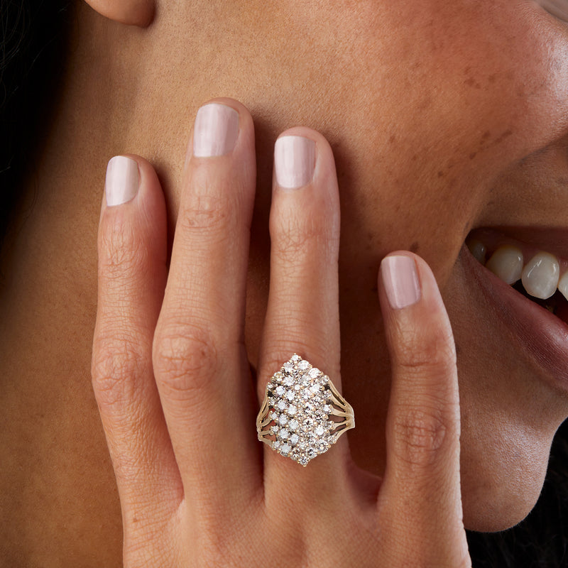 14kt yellow gold diamond cluster ring on finger, round stones surrounding the center