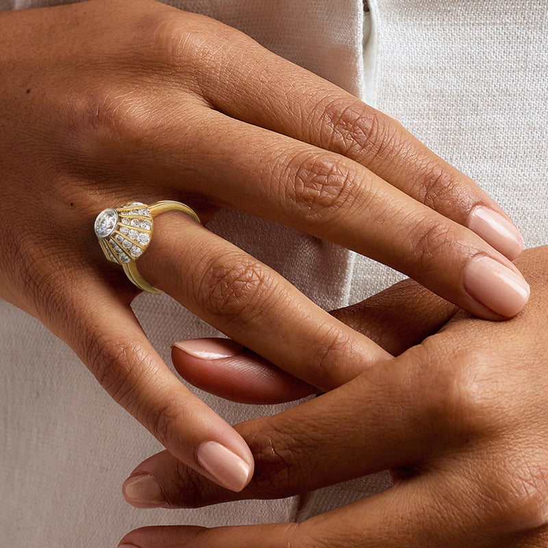 Diamond cluster heart-like dome ring in 18kt yellow gold on hand, prong-set stones