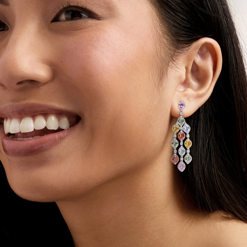 Sapphire and diamond drop earrings with colorful stones, worn on ear, gold post style