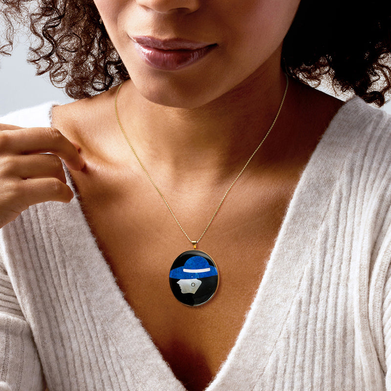 Gold chain pendant with round black enamel cameo, blue hat, and white profile
