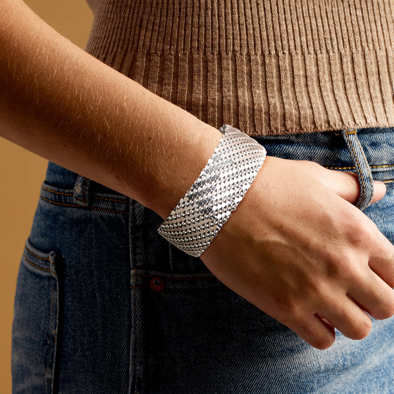 Rhodium-plated wide cuff bracelet worn on wrist, patterned crystal mesh cuff