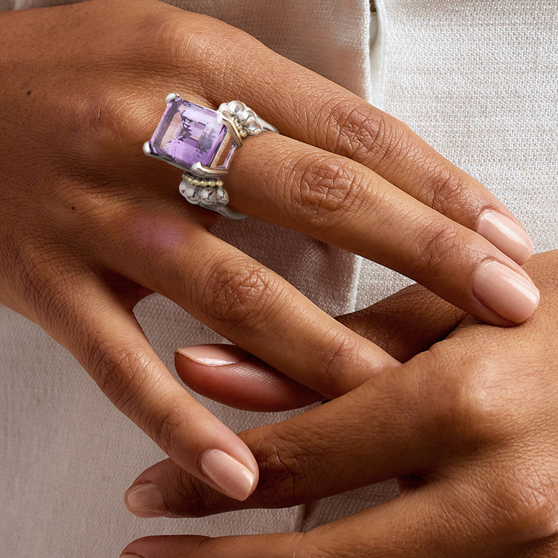 Amethyst ring worn on hand, rectangular purple stone in sterling silver setting with gold accents