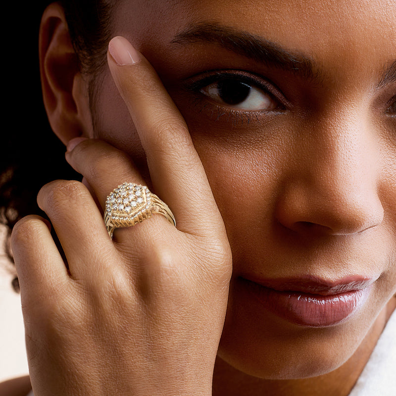 Yellow gold diamond cluster ring on hand with sparkling pave band