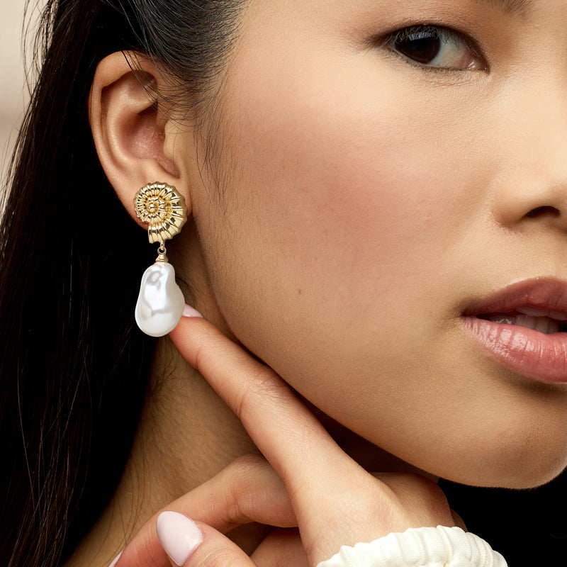 Gold-plated seashell drop earrings with baroque pearl-style drops worn