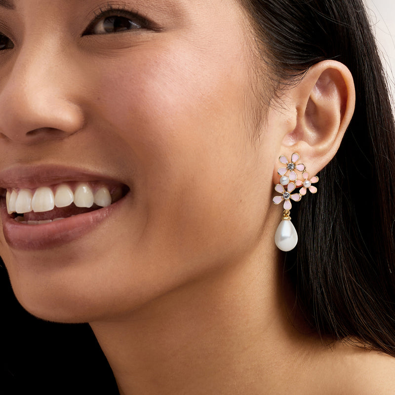 Pink enamel flower drop earrings on ear, faux gemstones with white pearl drop, gold tone