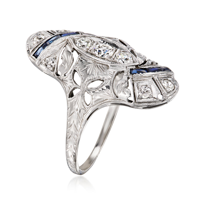 Vintage white gold ring with blue sapphire accents, ornate setting, and rectangular diamond-look stone