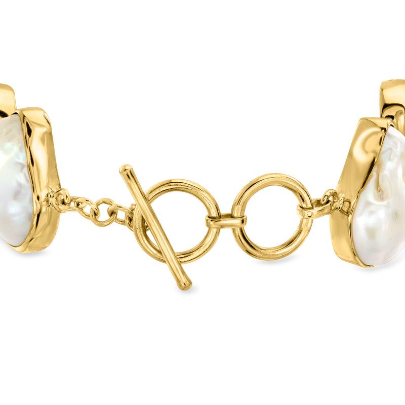 Gold-tone toggle clasp bracelet with white baroque pearls and curved bezel links
