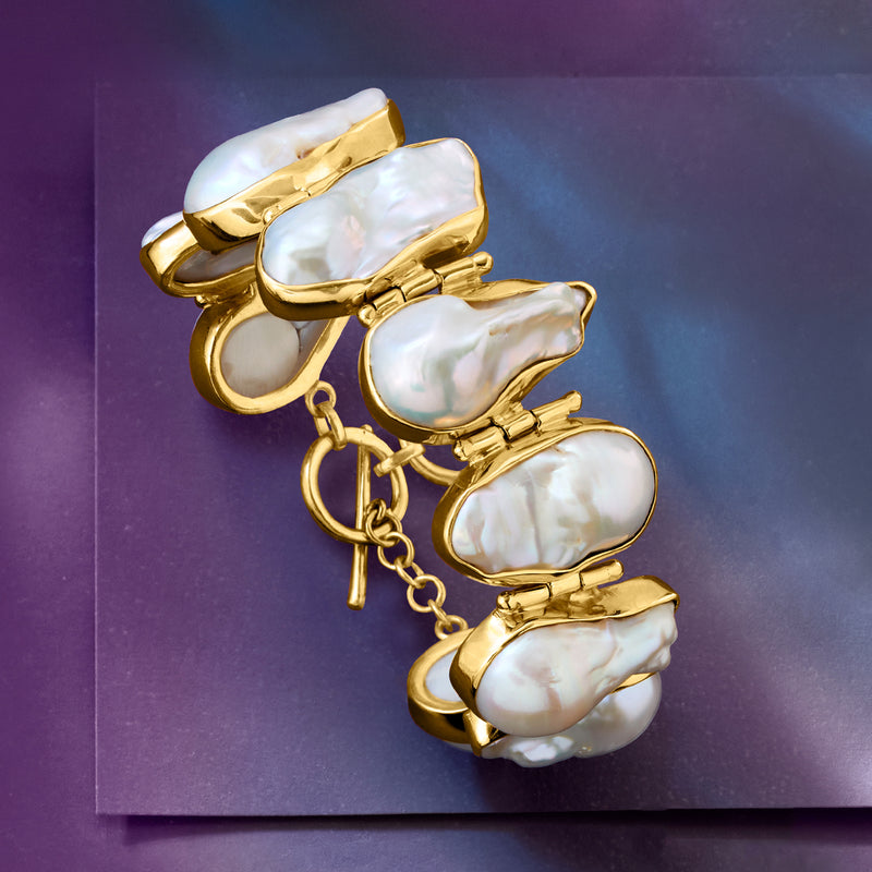 Baroque pearl bracelet with white iridescent oval pearls, gold settings, and chain