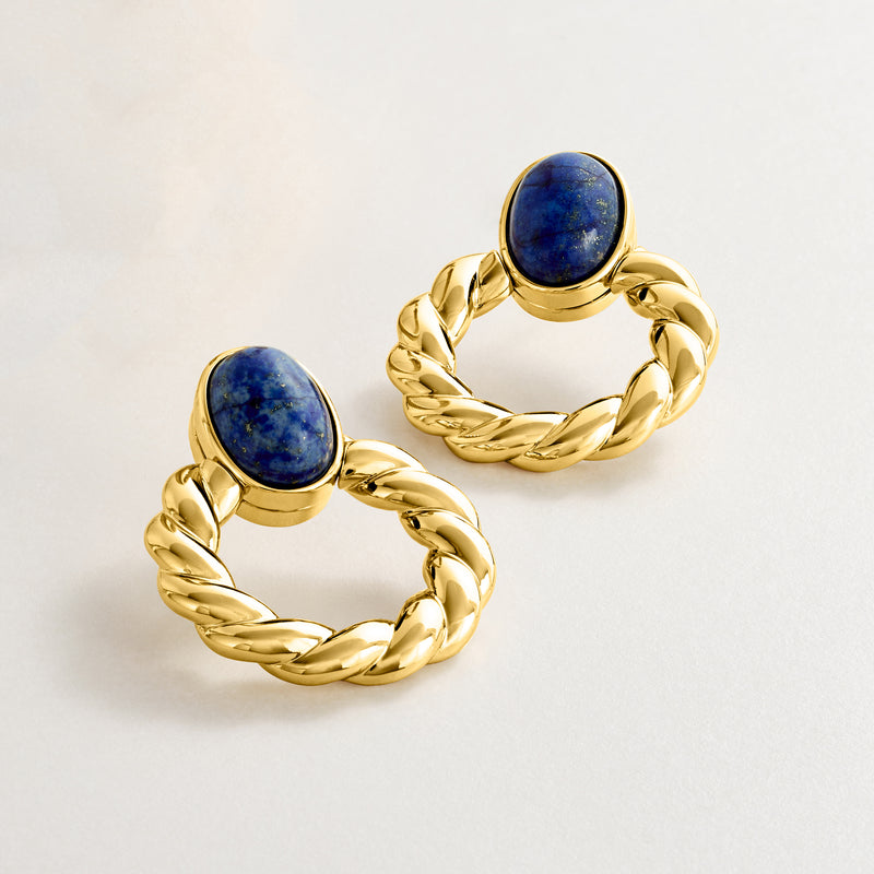 Twisted yellow gold-plated hoop earrings with blue lapis stones, angled view