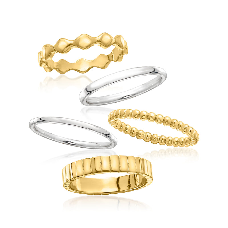 Stackable rings: wavy gold band, smooth silver band, beaded gold ring, and ribbed gold band