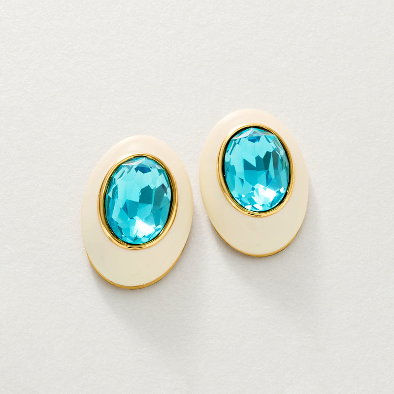 Pair of oval blue topaz post earrings with gold bezel and white enamel settings