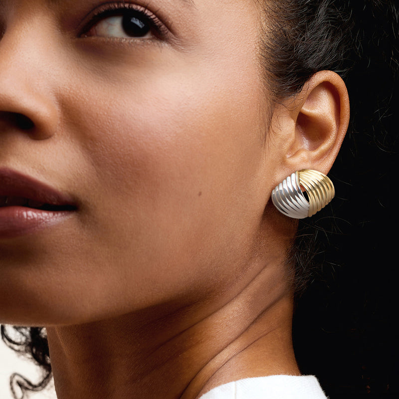 Twisted post earrings on ear, silver and gold-plated ribbed half-hoops