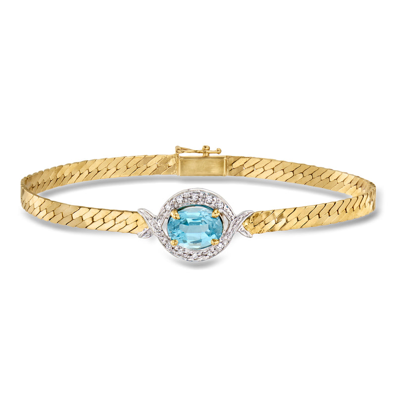 Two-tone gold tennis bracelet with oval blue topaz center and diamond halo