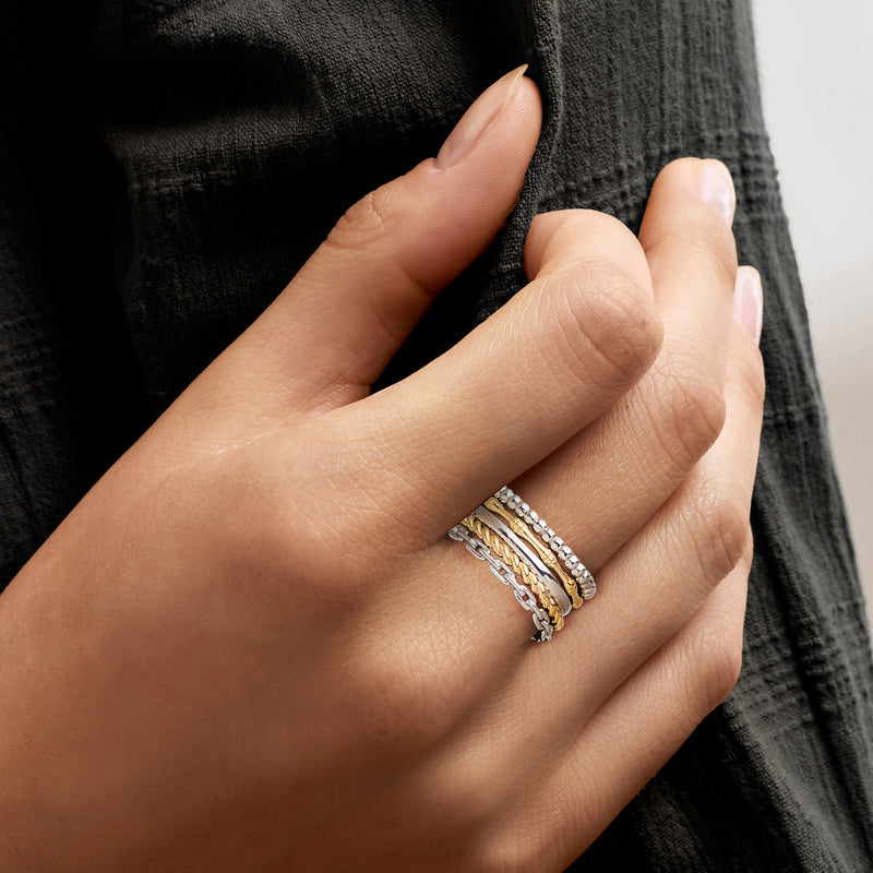 Five stackable rings in sterling silver and gold over sterling on a hand