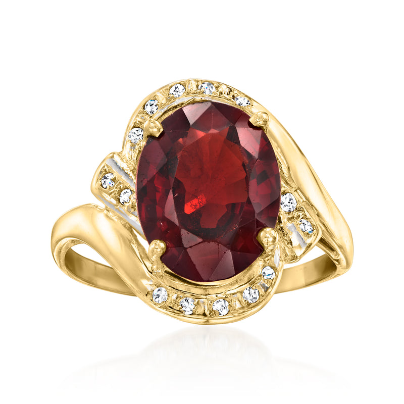 Vintage oval garnet ring in yellow gold with diamond halo and round sidestones