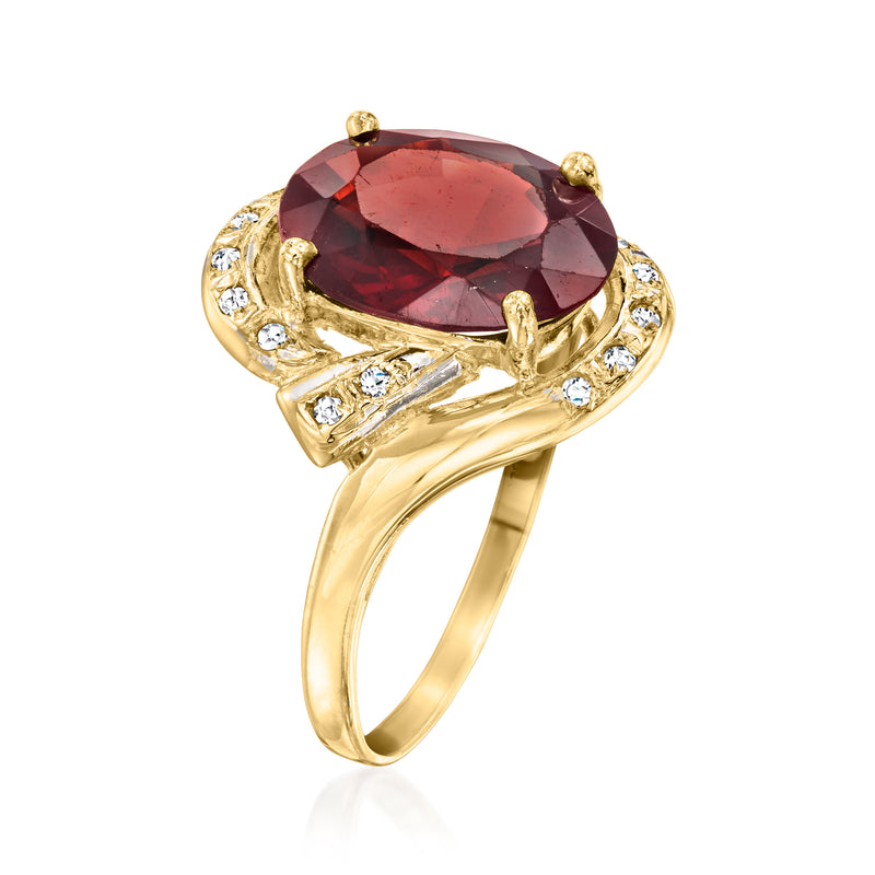 Oval garnet gemstone ring with yellow gold setting, diamond accents, and openwork shoulders