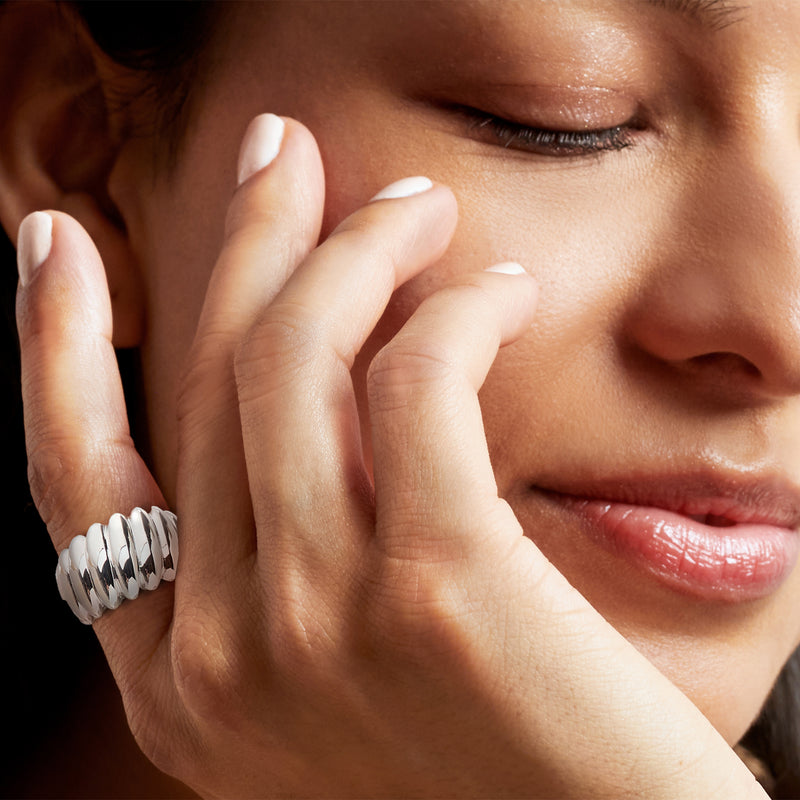 Rhodium-plated bubble ring worn on finger, rounded silver band