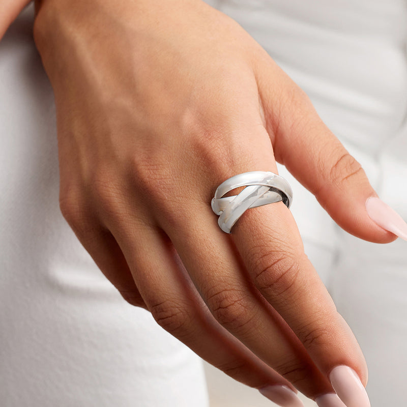 Rhodium-plated rolling ring worn on finger with interwoven polished bands