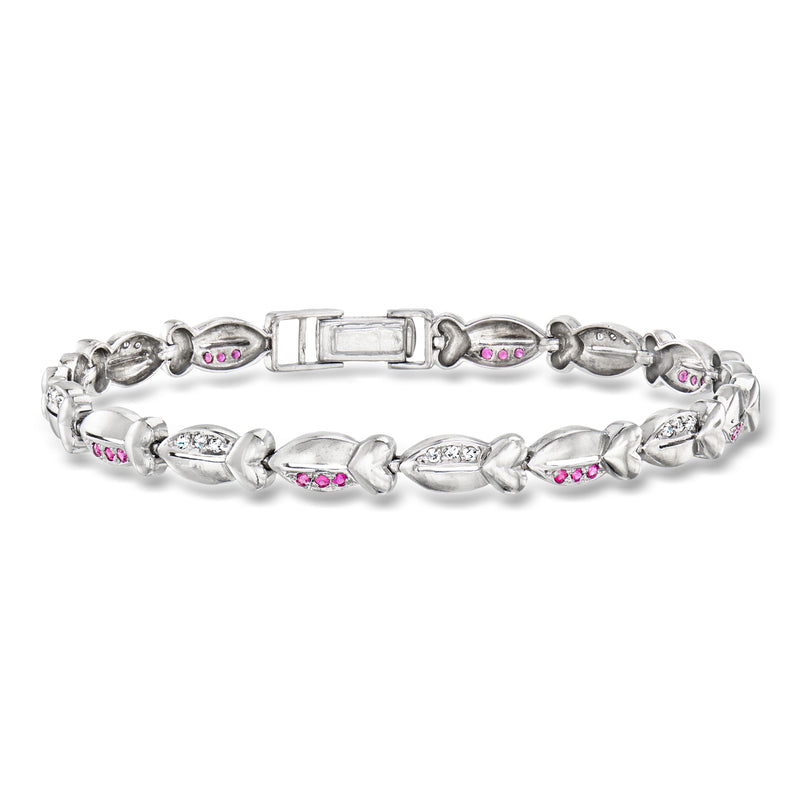 White gold tennis bracelet with oval ruby accents and small diamond clusters, hinged